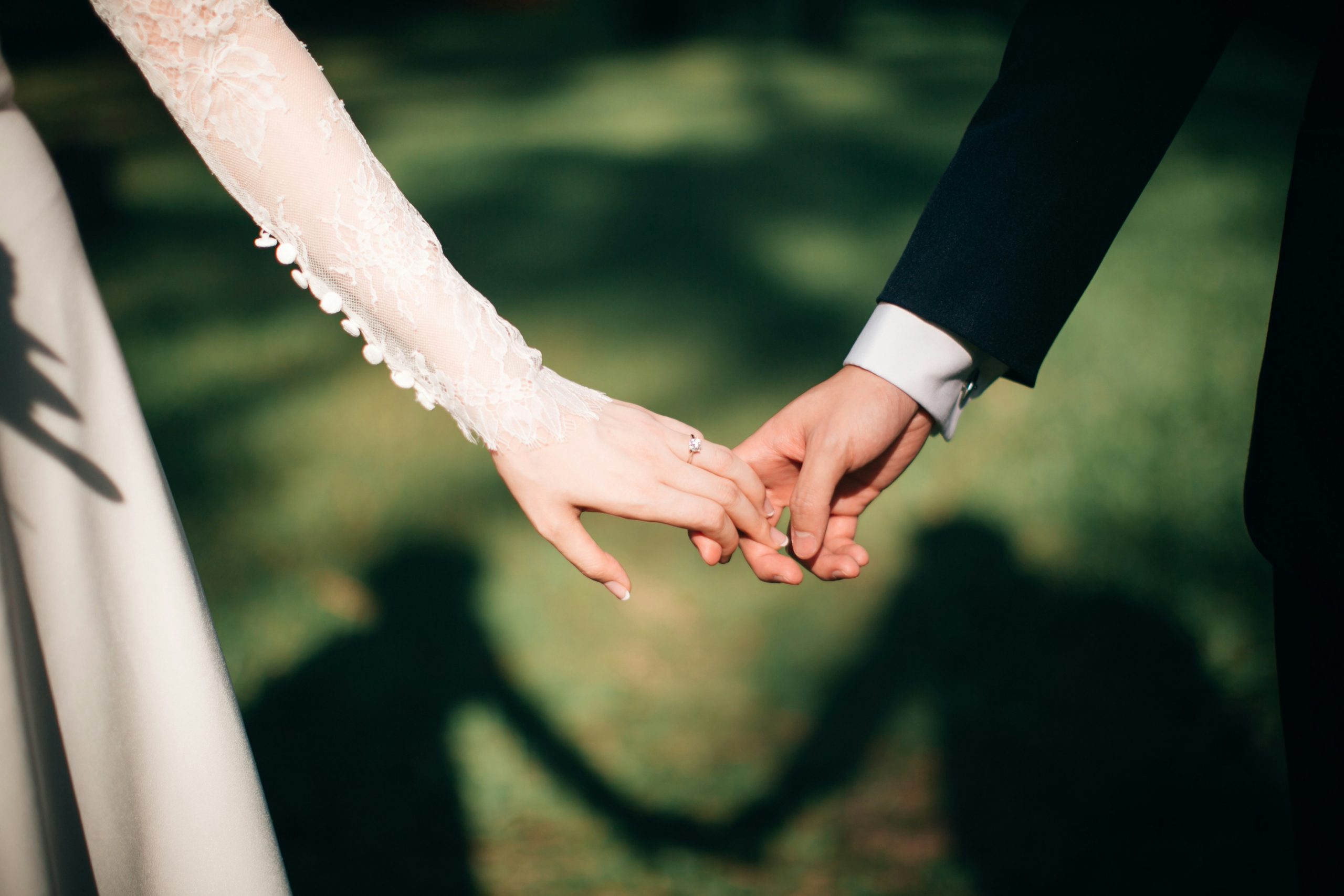 Bride and groom holding hands with red powder falling during an outdoor wedding ceremony